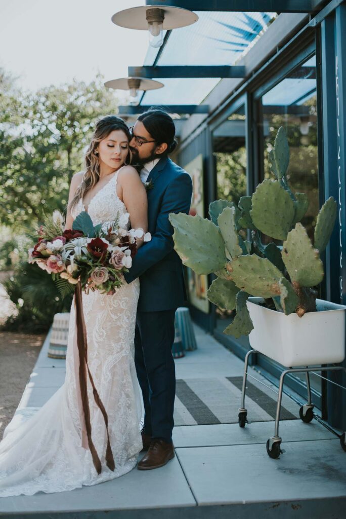 A couple poses in front of cactus at Ivy Hall Events